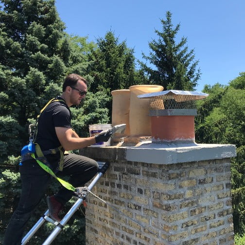 Lindemann service tech installing a chimney cap