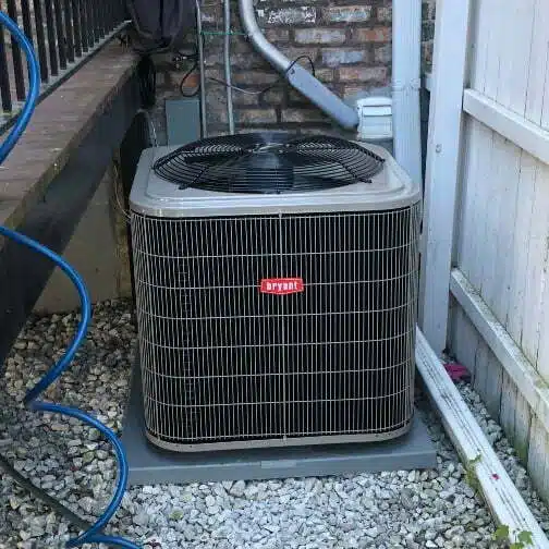 An AC unit on a pad outside of someone's home