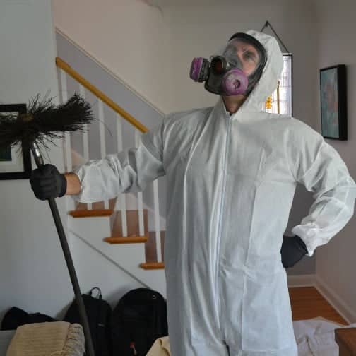 A Lindemann chimney sweep in full gear ready to clean a chimney