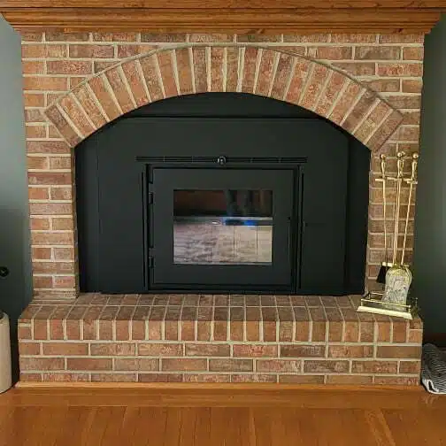 A pristine brick fireplace shown after repairs