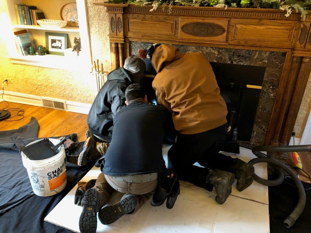 Lindemann service techs installing a fireplace insert
